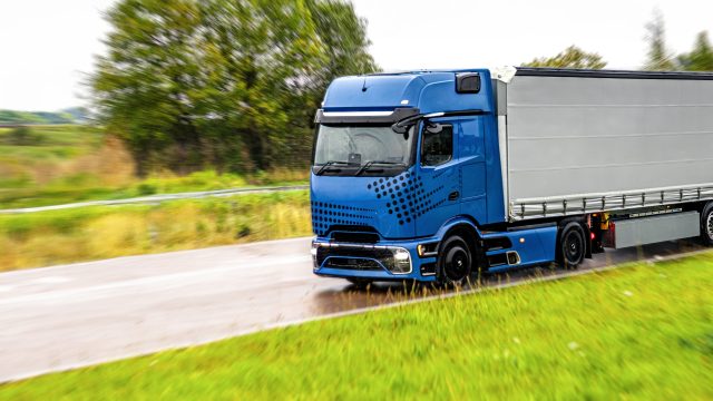 blue truck on wet road. power of modern logistics.